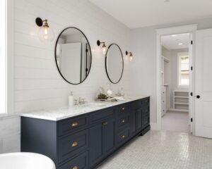 A city bathroom featuring two sinks and two mirrors with bathroom cabinets.