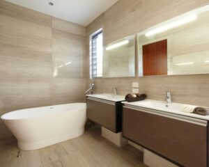A modern bathroom with two sinks and a tub, and tiled walls and floors.
