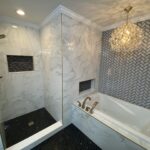 A marble bathroom with a luxurious tub and elegant chandelier.