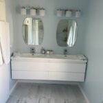 A white bathroom with two sinks and mirrors, perfect for a bathroom remodel.