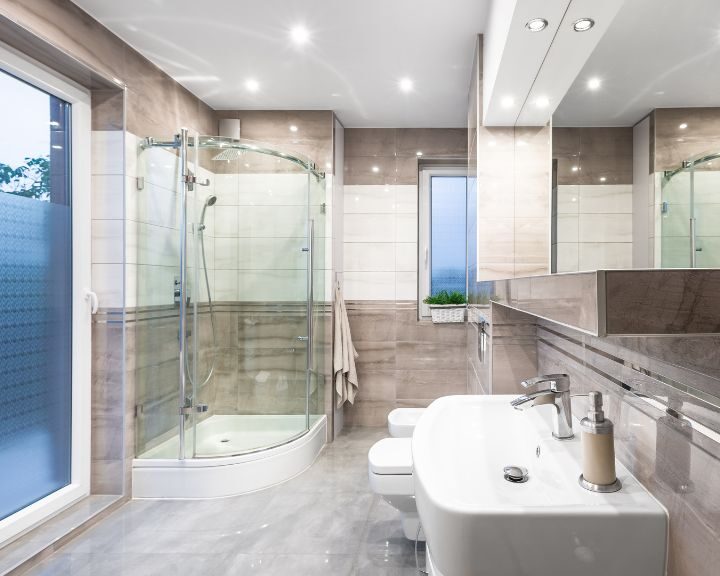 A modern bathroom with a glass shower stall and sink, featuring a sleek bathroom design.