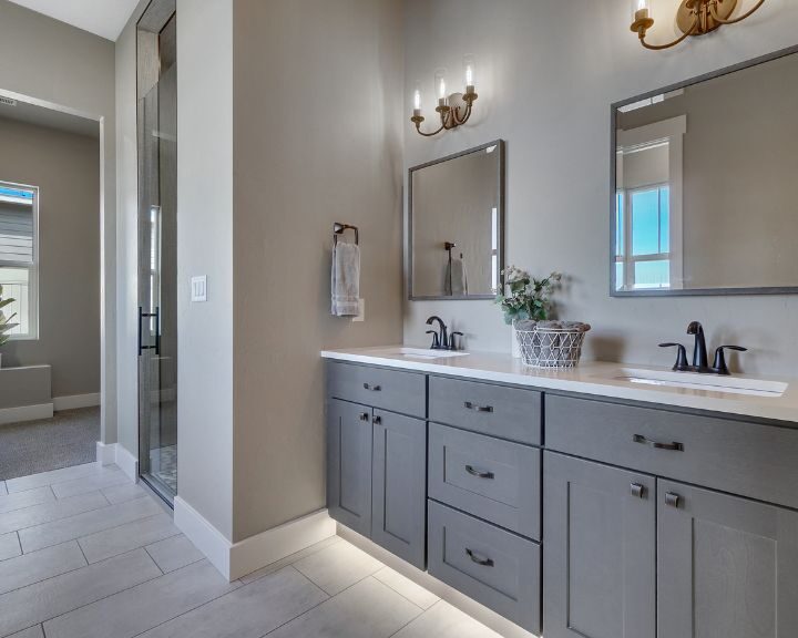 A bathroom with two sinks and a mirror featuring new cabinets in New Haven.