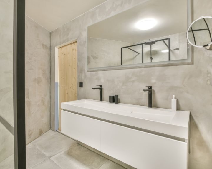 A modern bathroom countertop in the city with a white sink and mirror.