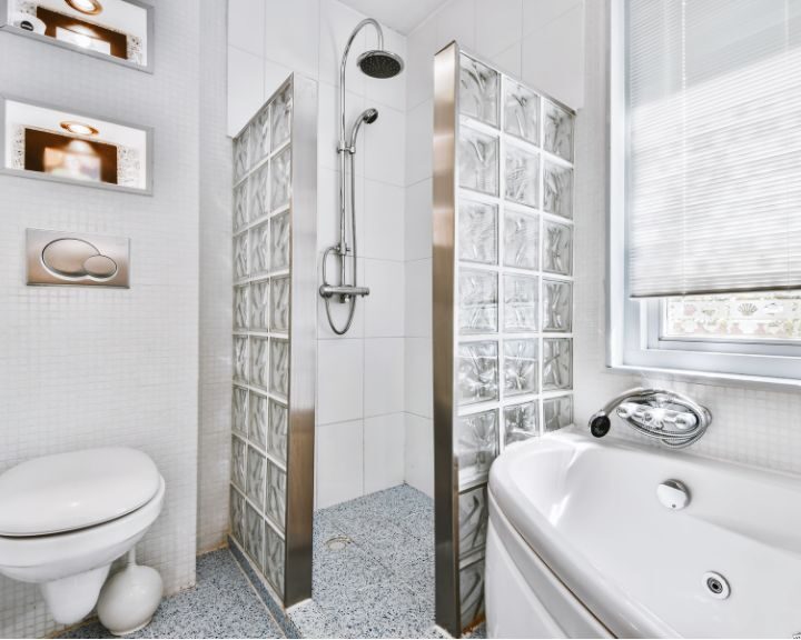 A bathroom with a glass shower stall.