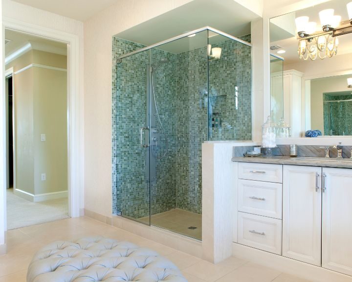A glass shower stall in a white bathroom.