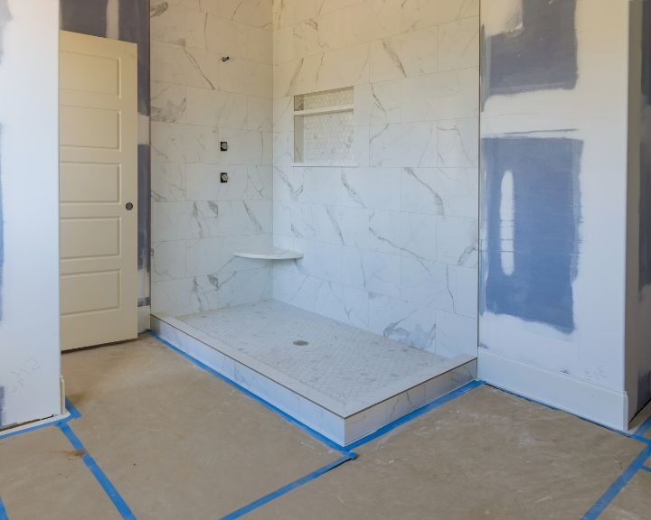 A bathroom that is being remodeled with blue tape, showcasing a new bathroom design.